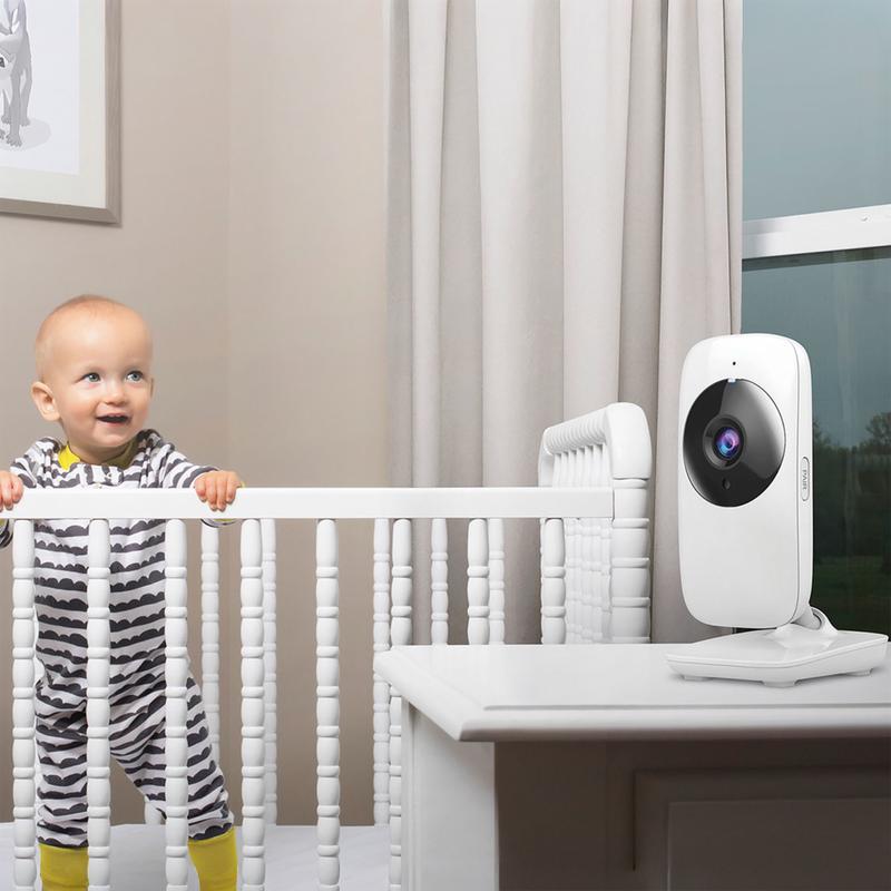 Babyunit van de Action babyfoon op een kast naast een wit babybedje Babyunit van de Action babyfoon op een kast naast een wit babybedje