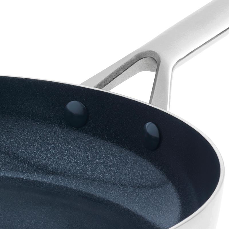 Close-up van de keramische coating en de stalen steel van een Blue Diamond pan van Action Close-up van de keramische coating en de stalen steel van een Blue Diamond pan van Action